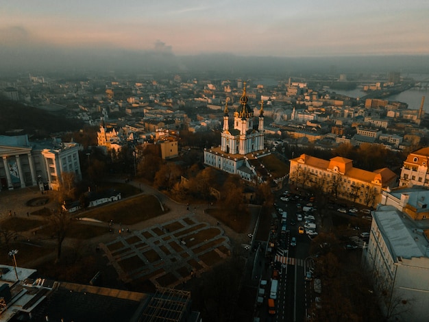 Aerial view from the drone on the roofs of houses and buildings at sunset in the city