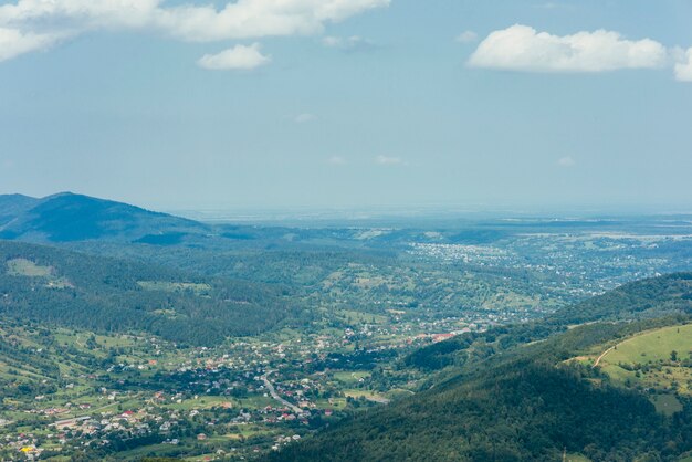 Aerial view of green mountain valley with town