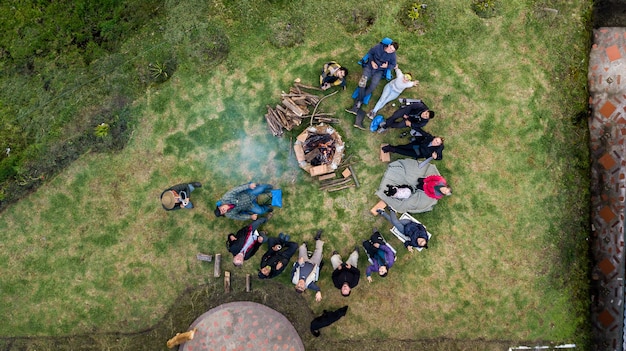 Aerial view of a group of people surrounding the fire pit at the campsite