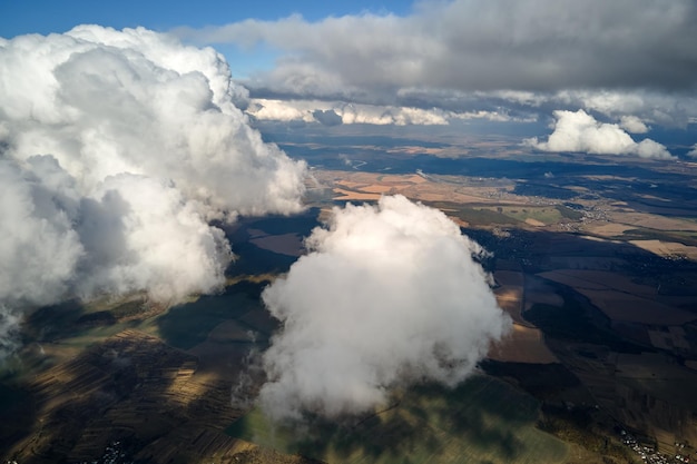 Free photo aerial view at high altitude of earth covered with puffy cumulus clouds forming before rainstorm