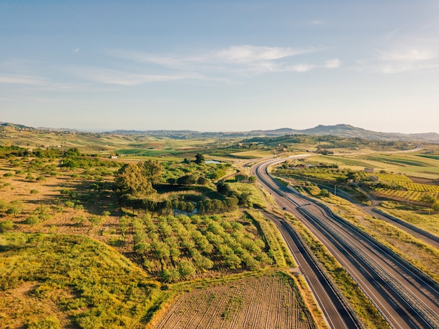 Вид с воздуха на шоссе в Италии с проезжающими мимо автомобилями