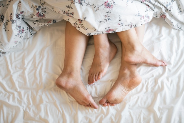 Aerial view of legs on bed