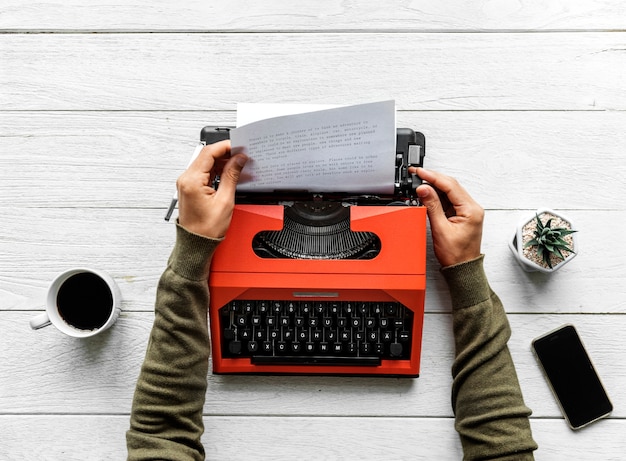 Free photo aerial view of a man typing on a retro typewriter