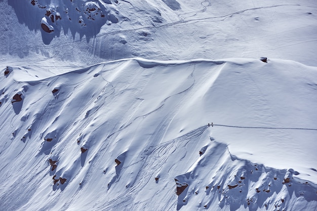 Aerial view of a mountain covered with white snow during winter