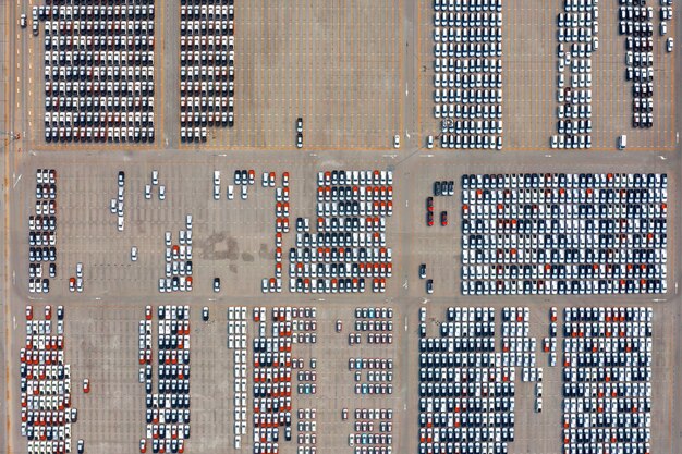 Aerial view of new cars at parking port in automobile factory.