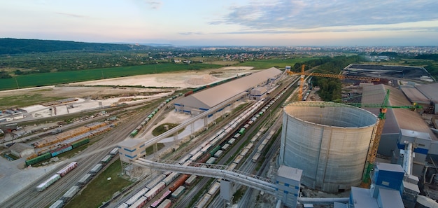 Вид с воздуха на строящийся цементный завод с высокой структурой бетонного завода и башенными кранами в зоне промышленного производства. производство и глобальная отраслевая концепция.