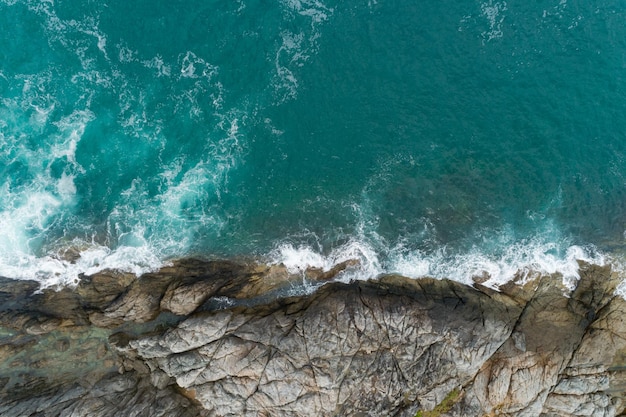 바다 충돌 파도의 공중 보기 해변 바위에 하얀 거품 파도 상위 뷰 환상적인 바위 해안 놀라운 자연 배경입니다. 프리미엄 사진