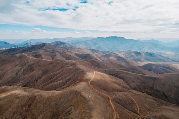 Aerial view of a path raising in to the mountains