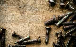 Free photo aerial view of rustic screws on wooden plank macro