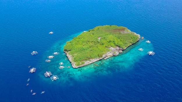 Aerial view of sandy beach with tourists swimming in beautiful clear sea water of the Sumilon island beach landing near Oslob, Cebu, Philippines. - Boost up color Processing.