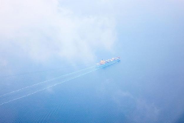 Aerial view of the sea with a passing cargo ship