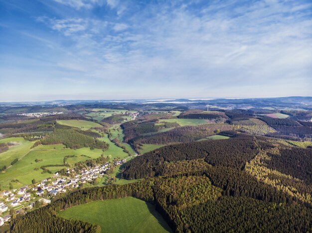 Вид с воздуха на красивые зеленые поля и дома в сельской местности в солнечный день