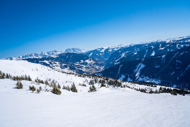 Aerial view of the skiers in a mountainous ski resort in the alps