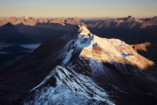 Free photo aerial view of snowy mountains with a clear sky