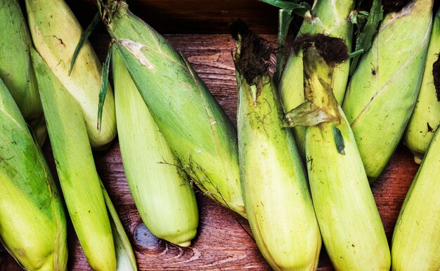 Aerial view of sweencorn cob on wooden background