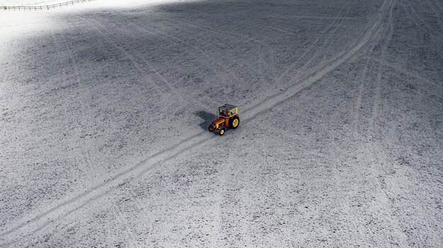 Aerial view of a tractor on a snowy field