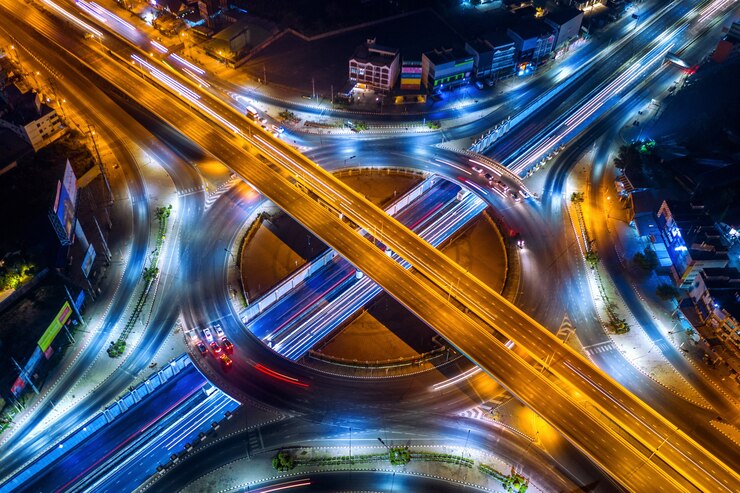 मुफ़्त फोटो aerial view of traffic in roundabout and highway at night.