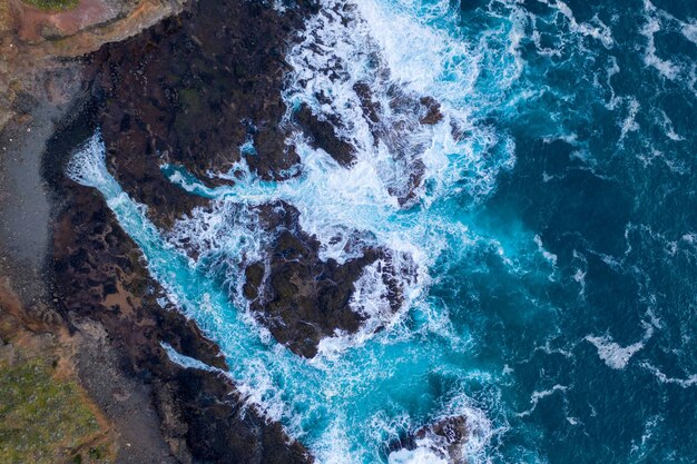 Aerial view of waves crashing on rocks