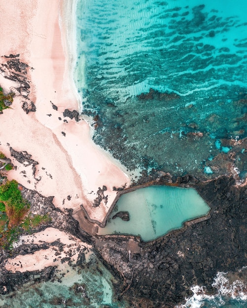 Free photo aerial view of waves crashing on rocks