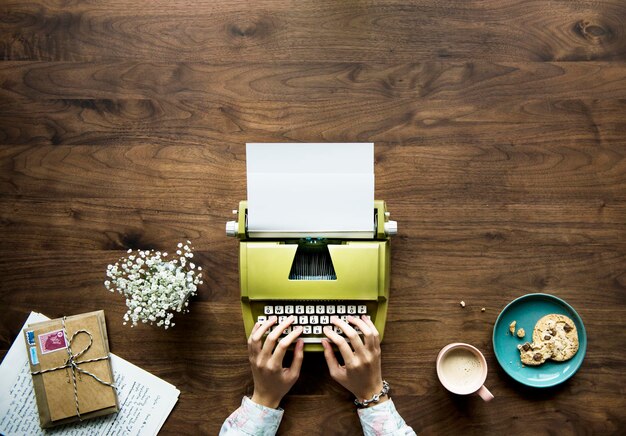 Aerial view of a woman typing on a retro typewriter blank paper