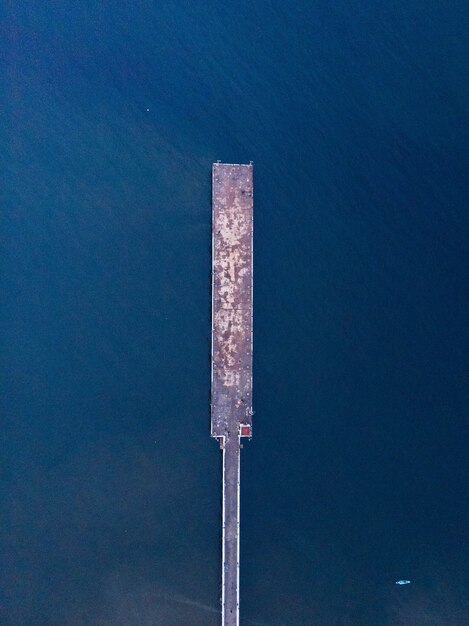 Aerial view of a wooden pier on a blue sea