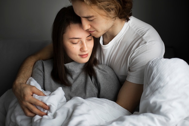 Affectionate couple cuddling in bed