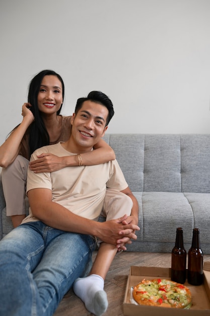 Affectionate couple at home having pizza and beer