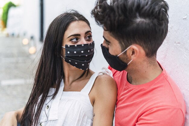 Affectionate couple wearing masks and showing love to each other