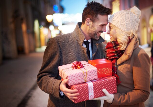 Affectionate couple with stack of presents