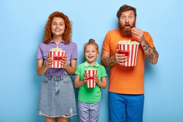 Affectionate ginger family posing with popcorn