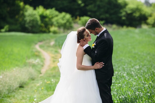 Affectionate groom touching his wife's face outdoors