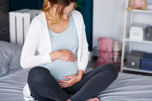 Free photo affectionate pregnant woman touching her belly at home