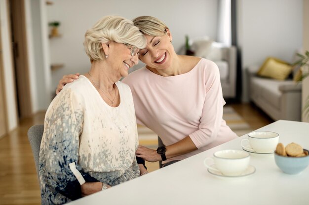 Affectionate woman and her senior mother spending time together at home