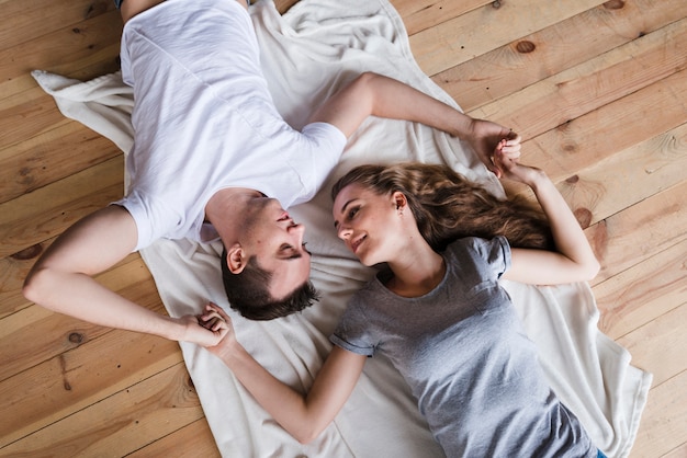 Affectionate woman holding hands of sleeping husband