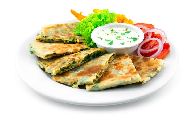 Afghani bolani is a  chives vegan stuffed flatbread traditional popular of afghanistan, india served yogurt dipping sauce decoration carving chili and vegetables sideview