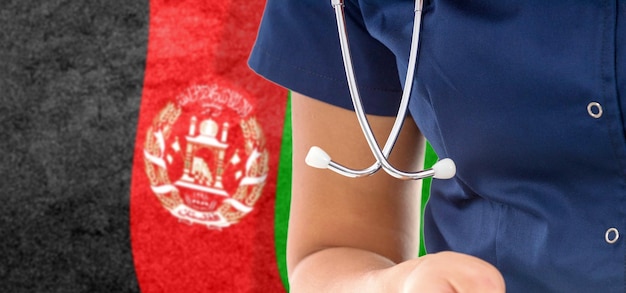 Medico femminile della bandiera dell'afghanistan con lo stetoscopio, sistema sanitario nazionale