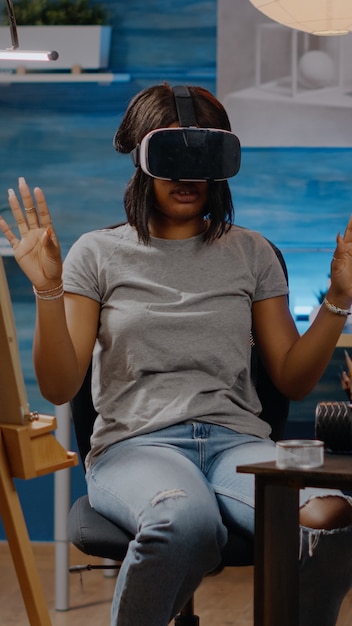 African american artist with vr glasses using technology to draw authentic white vase for fine art concept at studio. Black young woman with modern headset goggles used for drawing