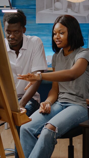 African american artists analyzing drawing of vase