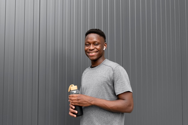 Free photo african american athlete holding a bottle of water