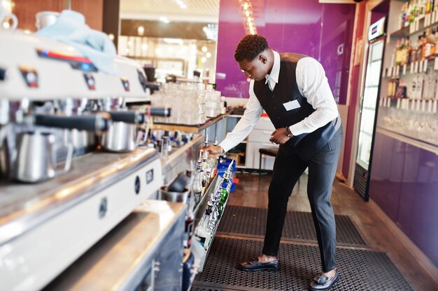 African american bartender at bar holding bootle Alcoholic beverage preparationxA