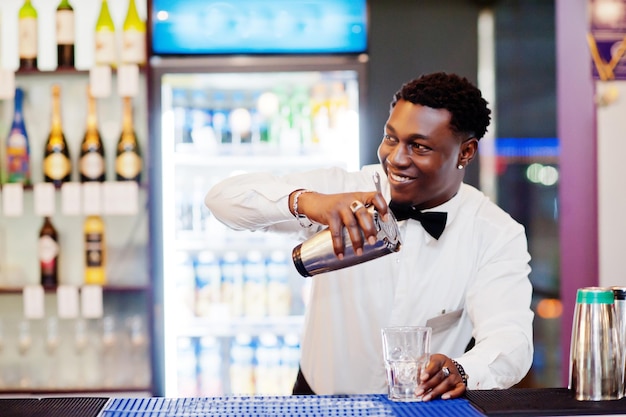 African american bartender at bar with shaker Alcoholic beverage preparationxA