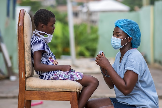 Free photo african-american boy getting a checkup by a doctor