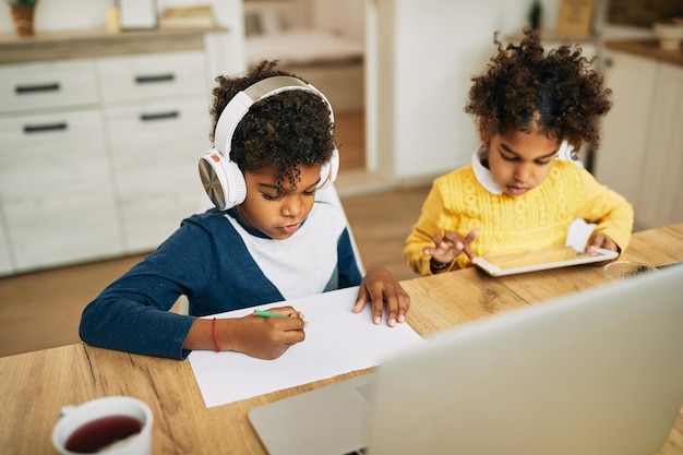 アフリカ系アメリカ人の男の子と女の子が家で学ぶ