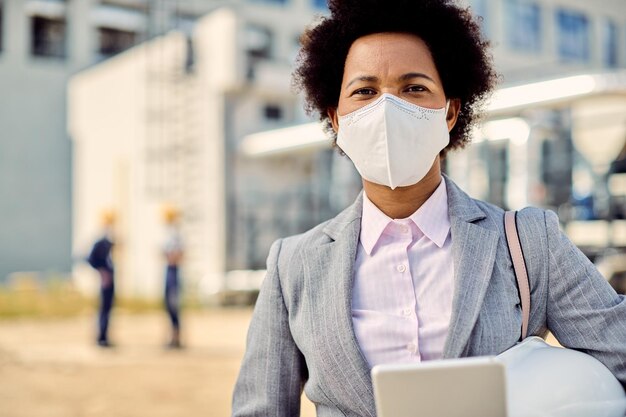 Free photo african american building contractor with protective face mask at construction site