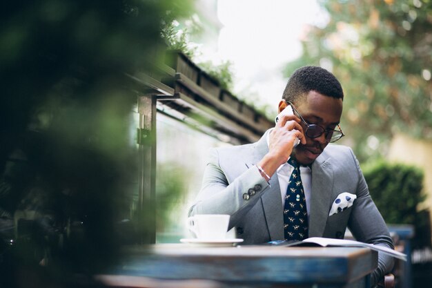 African american business man reading news and talking on phone