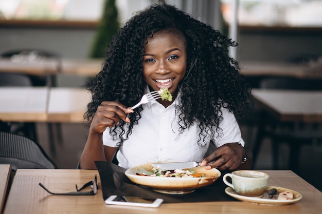 カフェでサラダを食べるアフリカ系アメリカ人のビジネス女性