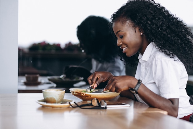 Афроамериканец бизнес женщина есть салат в кафе
