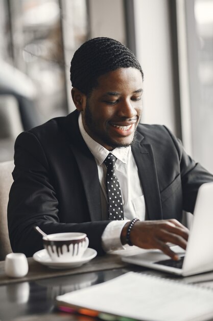 African American businessman using a laptop in a cafe.