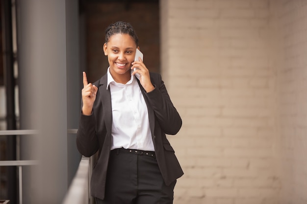 African-american businesswoman in office attire smiling, looks confident and happy, successful