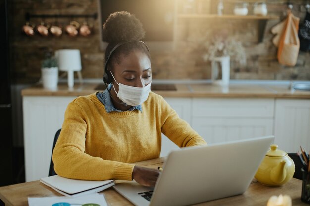 COVID19 전염병으로 인해 집에서 일하는 동안 컴퓨터를 사용하는 아프리카계 미국인 여성 사업가